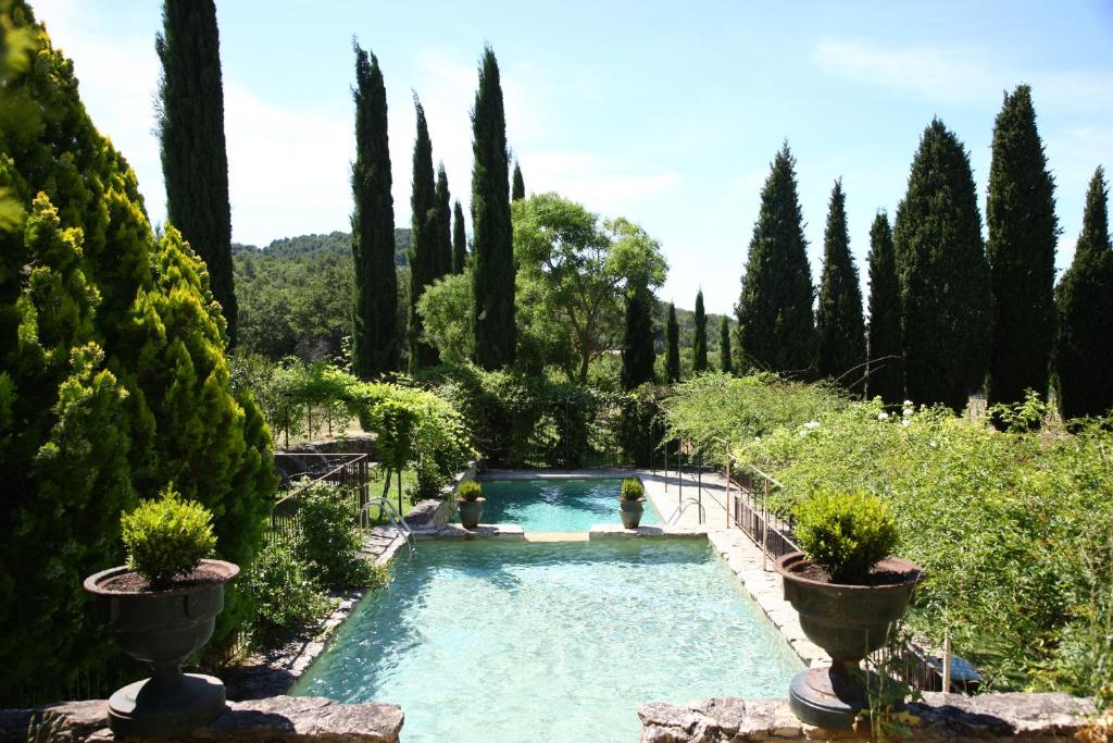 einen Pool in einem Garten mit Bäumen in der Unterkunft La Bastide de Marie, Maisons et Hôtels Sibuet in Ménerbes