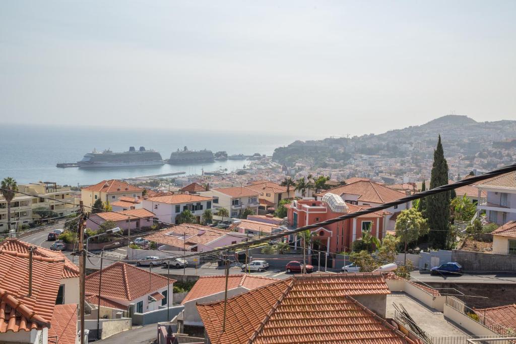 vistas a una ciudad con barcos en el agua en Rochinha House, en Funchal