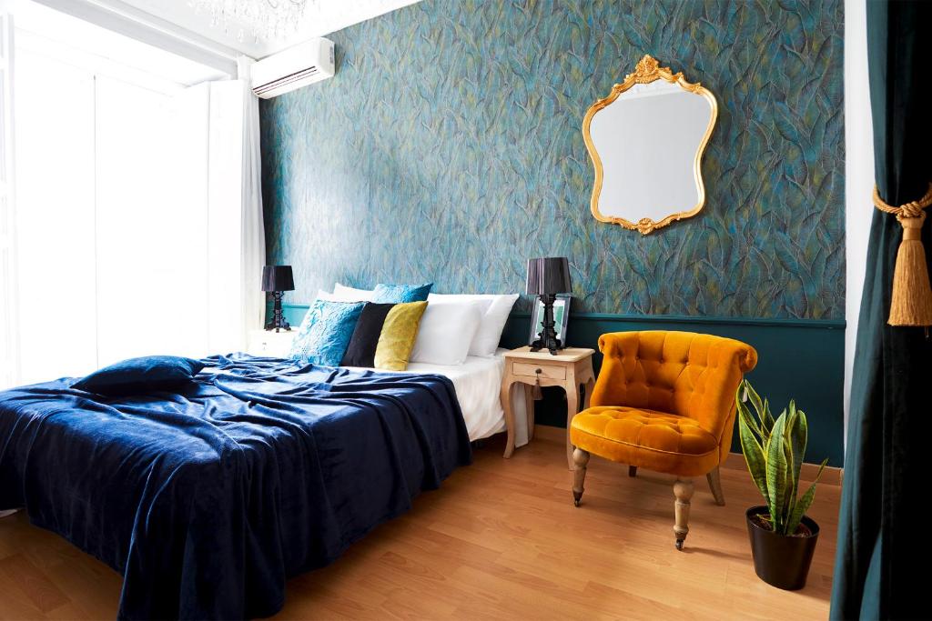 マドリードにあるSanta Ana Boutiqueのベッドルーム1室(ベッド1台、椅子、鏡付)