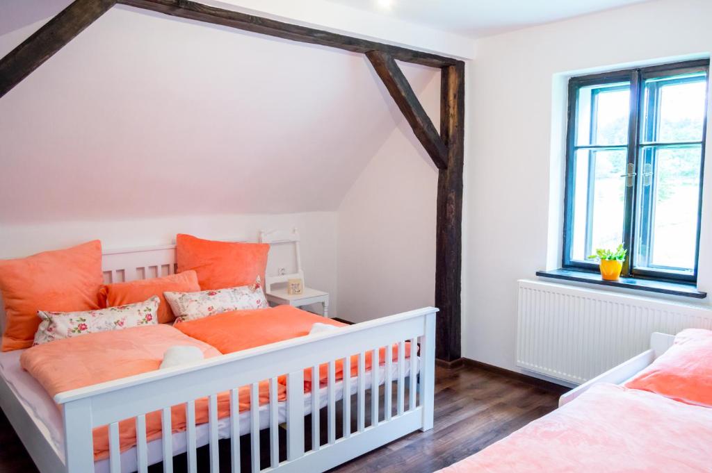 ein Kinderzimmer mit Kinderbett und orangefarbenen Kissen in der Unterkunft Apartment-Chalet-Chaloupka U Trnků in Lázně Kynžvart