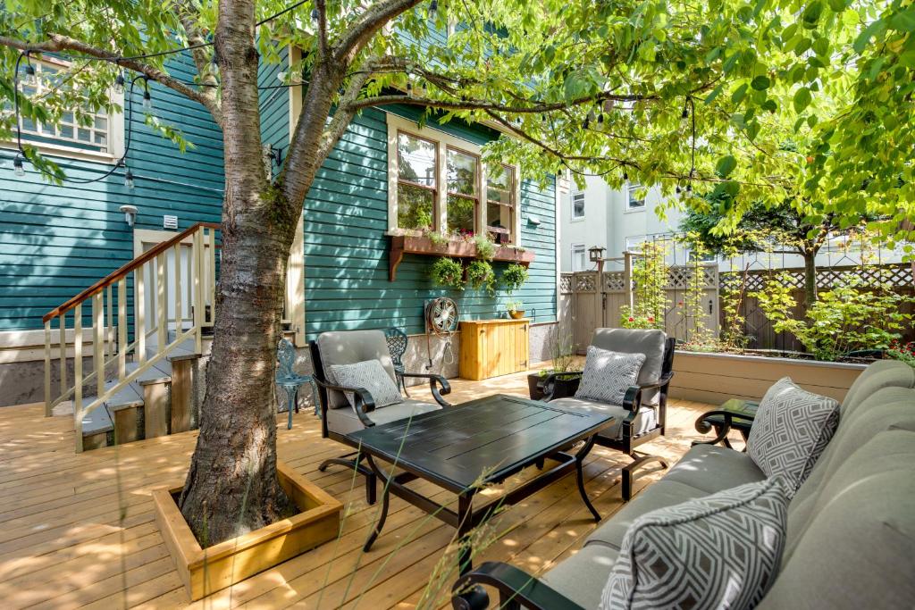 a patio with a table and chairs and a tree at O Canada House Bed & Breakfast in Vancouver