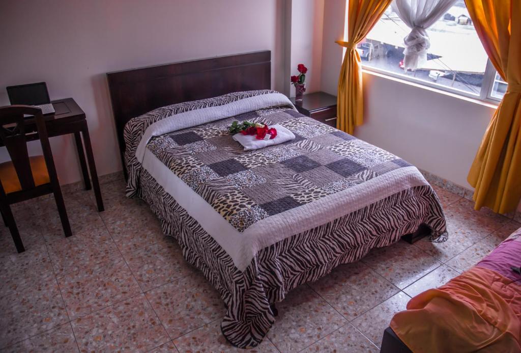 Postel nebo postele na pokoji v ubytování Hostal La Rosa Otavalo