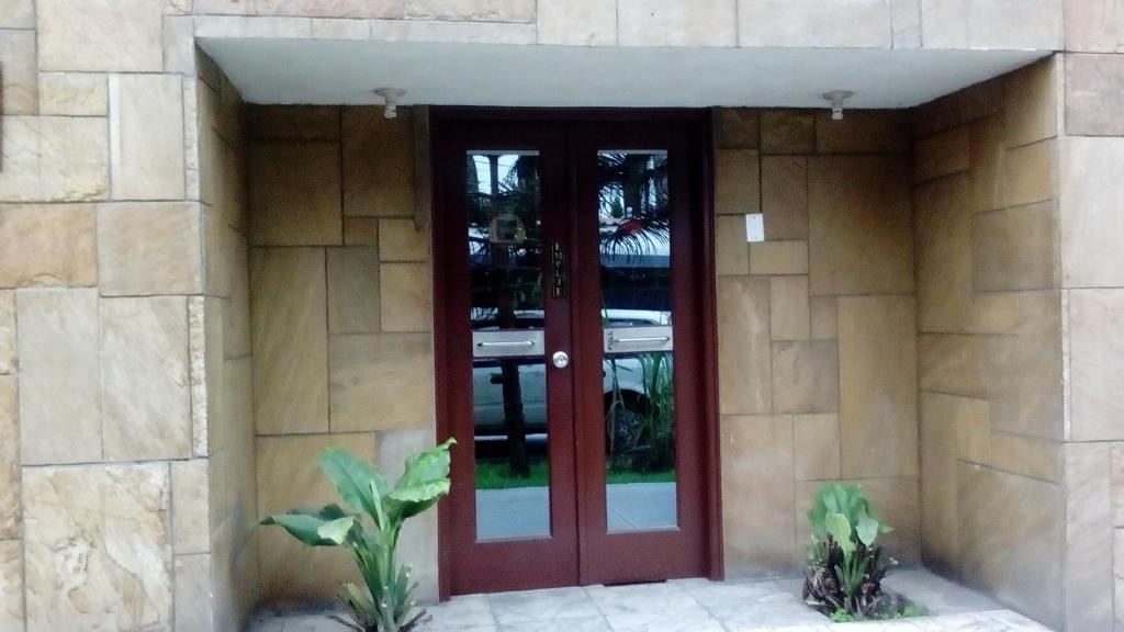 una puerta roja en el lateral de un edificio en Hostal Inversiones Huachipa, en Lima