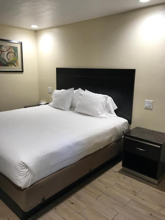 a bedroom with a large bed with white sheets and pillows at Colton Inn in Colton