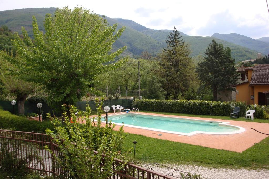 a swimming pool in a yard with mountains in the background at Affitta camere Il Ruscello in Scheggino