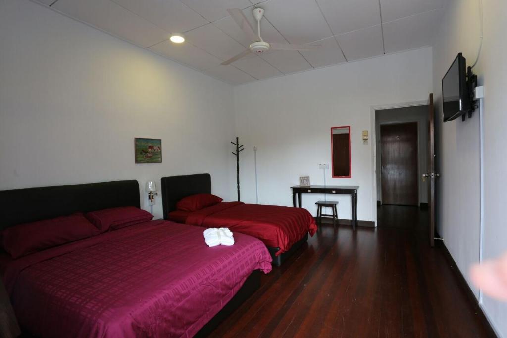 a living room with two beds and a table at Bee's Homestay in George Town