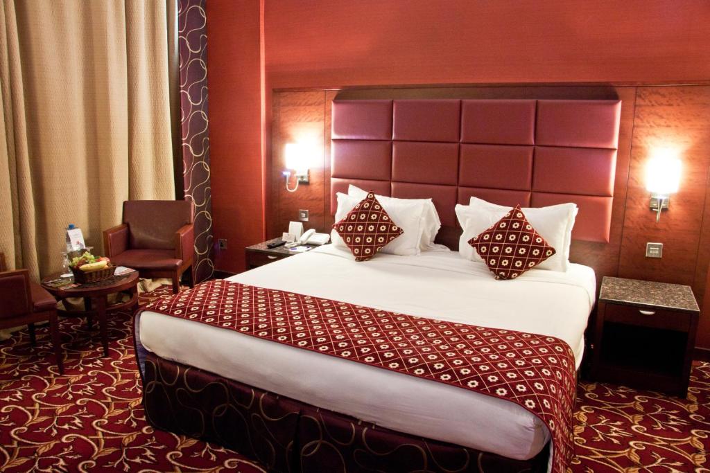 a hotel room with a large bed with pillows at Ramee Rose Hotel in Dubai