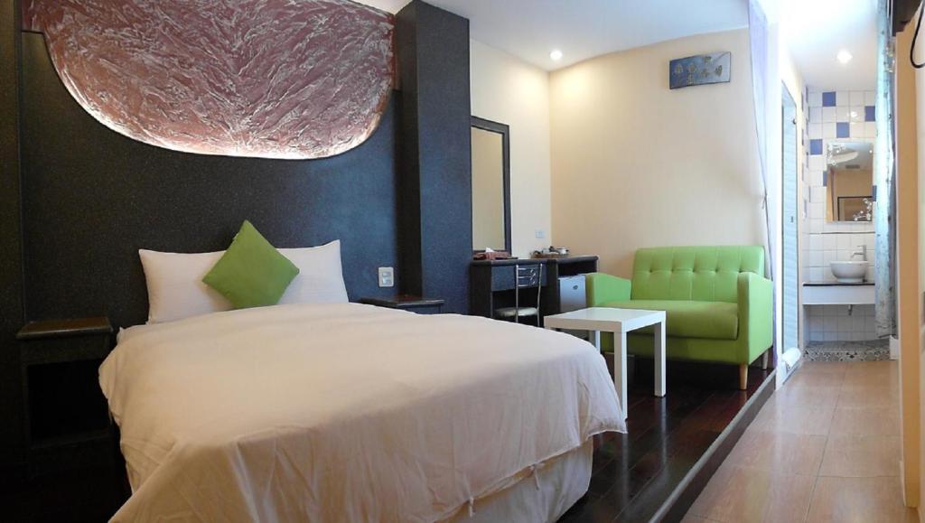 1 dormitorio con 1 cama y 1 silla verde en Kenting Sea Cloudless Day Home, en Kenting