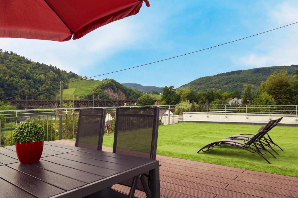 a patio with a table and chairs on a deck at Ferienwohnung Brautrock in Bullay