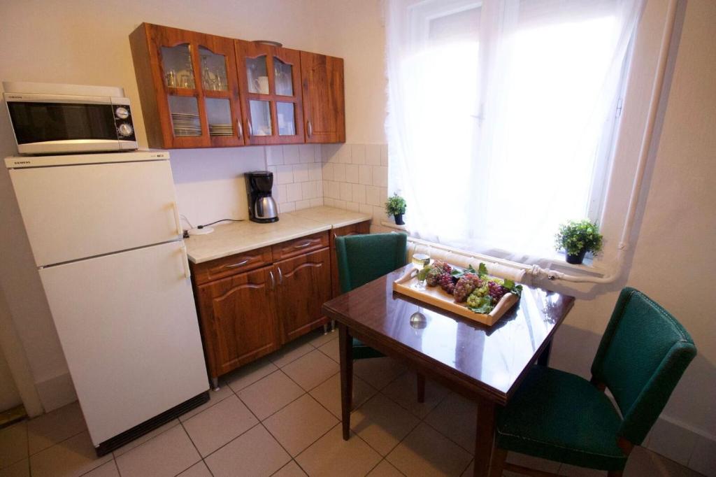 a small kitchen with a table and a refrigerator at Malomtavi Vendégház in Tapolca