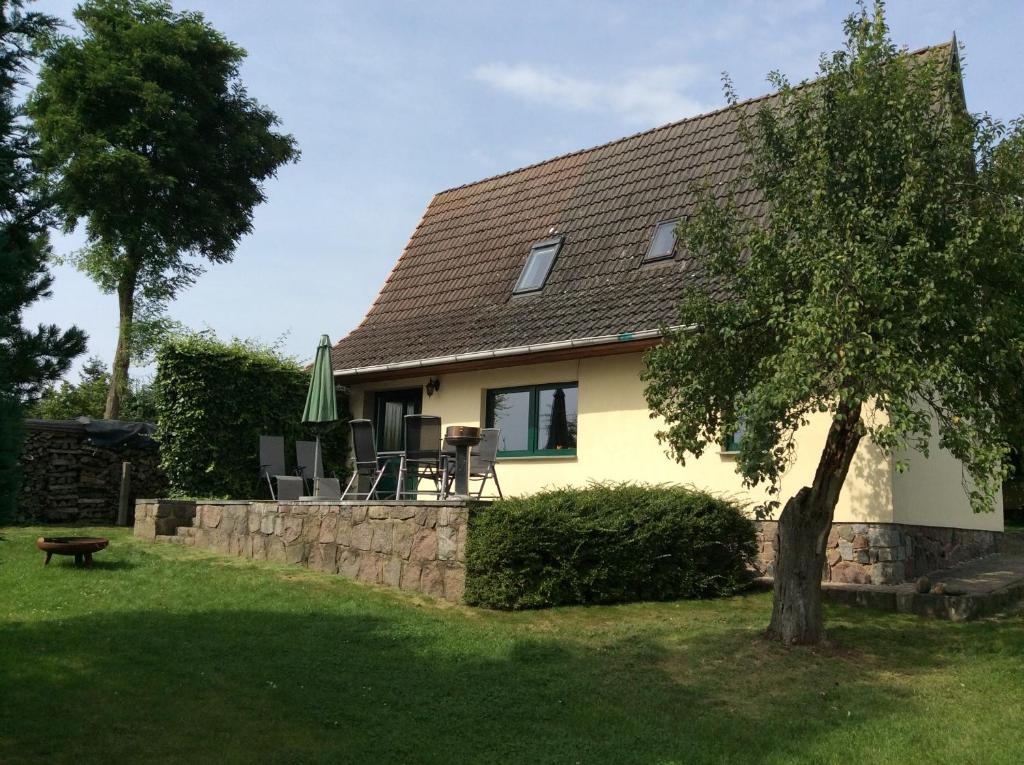 een geel huis met een tafel en stoelen in een tuin bij Zurück zur Natur... in Vollrathsruhe