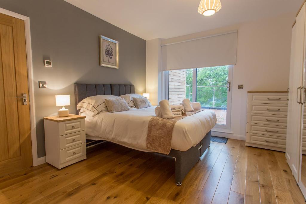 a bedroom with a large bed and a window at Razia Apts with easy access to Oxford Headington Hospitals in Oxford