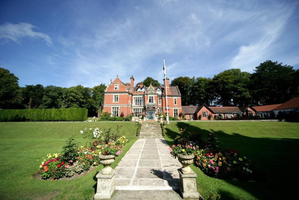 a large house with flowers in front of it at The Coed-Y-Mwstwr Hotel in Bridgend