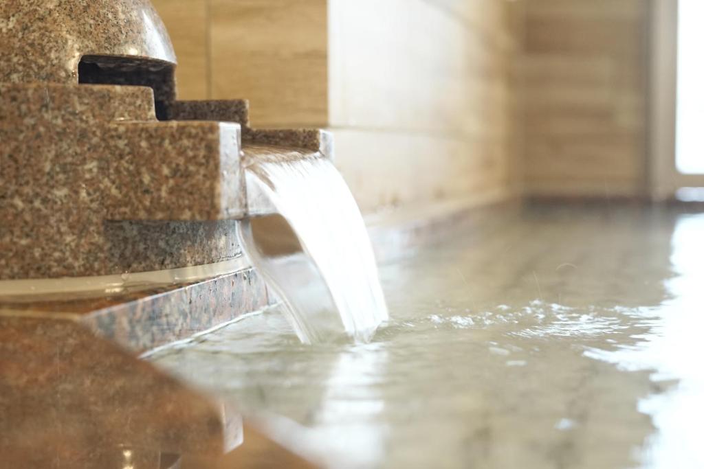 a water fountain in the middle of a room at Hotel La'gent Plaza Hakodate Hokuto in Hokuto