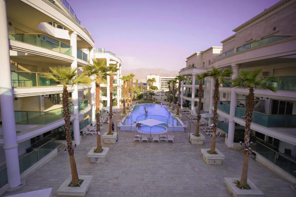 an empty courtyard with palm trees and a swimming pool at City Resort Palmore in Eilat