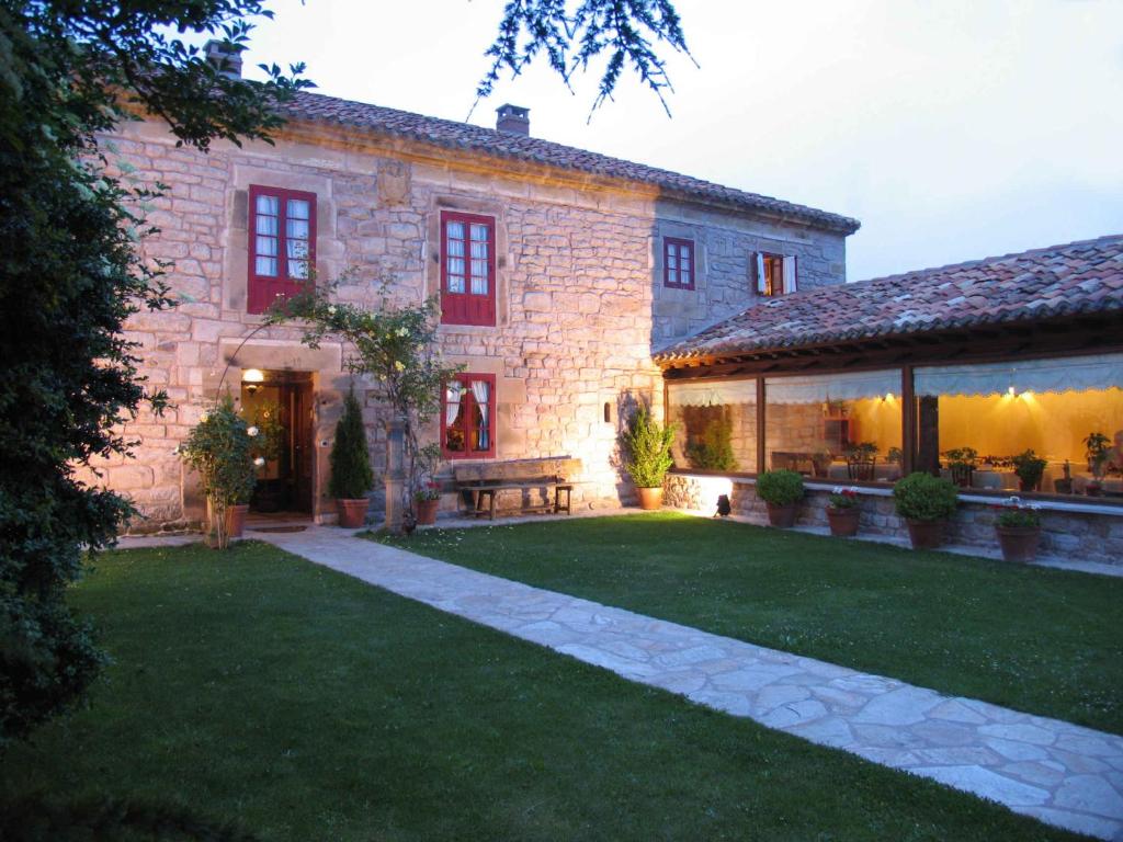 a large stone house with a lawn in front of it at Casa de Campoo in Naveda