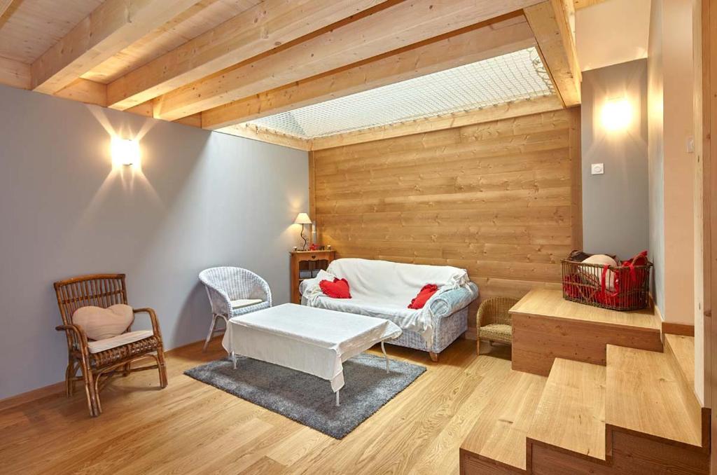 a bedroom with a bed and a table and a chair at La Maison des Coeurs in Attignat-Oncin