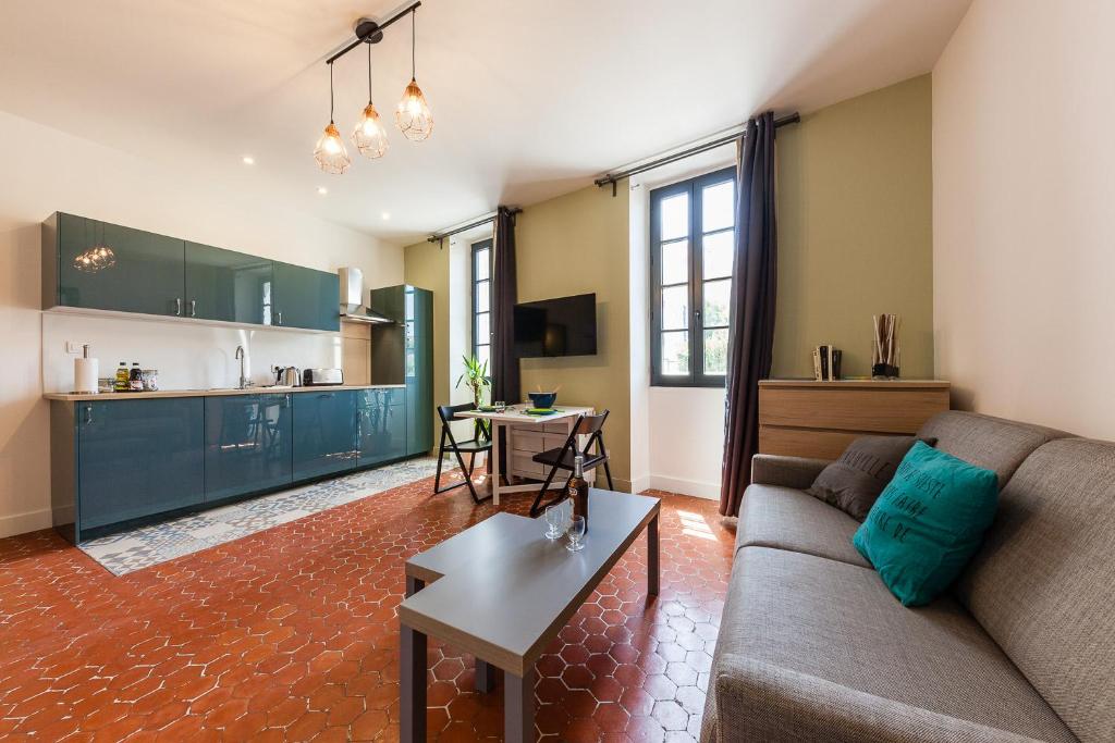 a living room with a couch and a table at Chez Nous - 7 Appartements sur le Vieux Port in Marseille