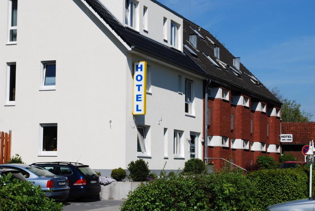 ein weißes Hotel mit einem Schild an der Seite in der Unterkunft Hotel Lohmann in Münster