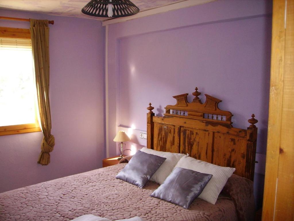 een slaapkamer met een groot bed met 2 kussens bij Ca les Barberes in Paúls