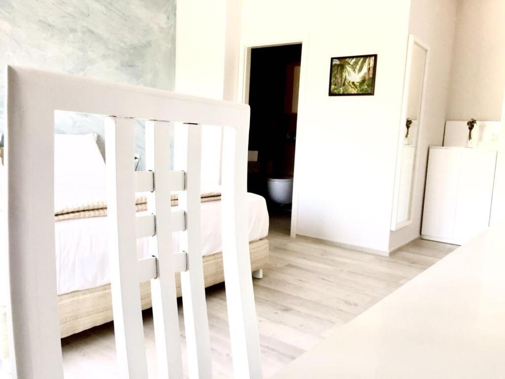 una camera bianca con un letto e una scala bianca di Amberyellowbnb a Shkodër