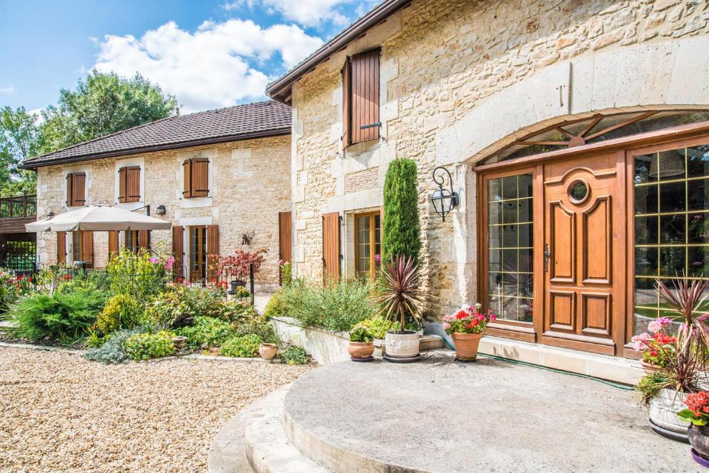 een stenen huis met een binnenplaats met potplanten bij Moulin du Fontcourt in Chasseneuil-sur-Bonnieure