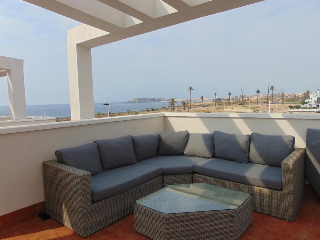 a couch on a balcony with a view of the ocean at Villa Vistamar in Puerto de Mazarrón