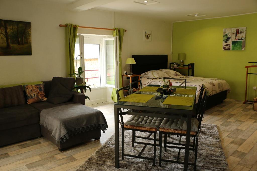 a living room with a bed and a table and a couch at Appartement T1 in Dun-les-Places