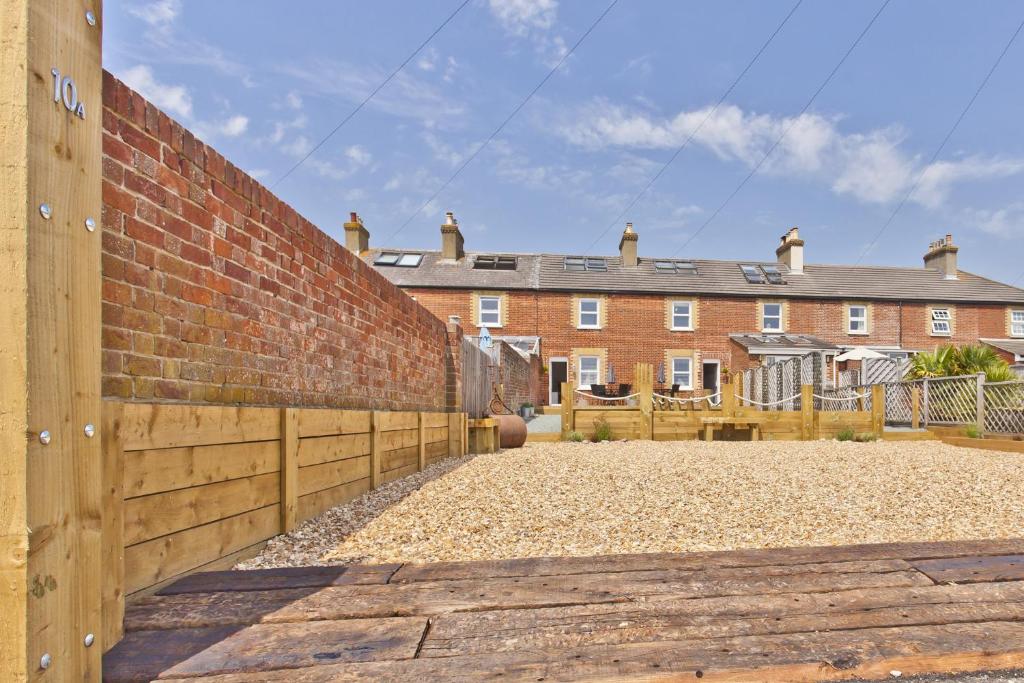 a brick wall with a fence in front of a house at Seaside Cottage in Bournemouth