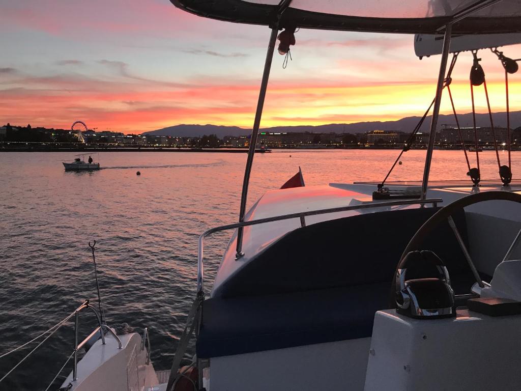 a boat in the water with a sunset in the background at Floatinn Boat-BnB in Geneva