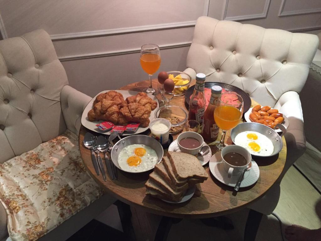 een ontbijttafel met eieren en brood en glazen sinaasappelsap bij Venetian Signature PoolView Resort Jomtian Pattaya in Jomtien Beach