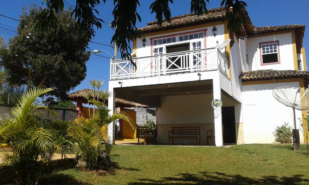 ein weißes Haus mit einem Balkon und einem Hof in der Unterkunft Casa de Maria in Tiradentes