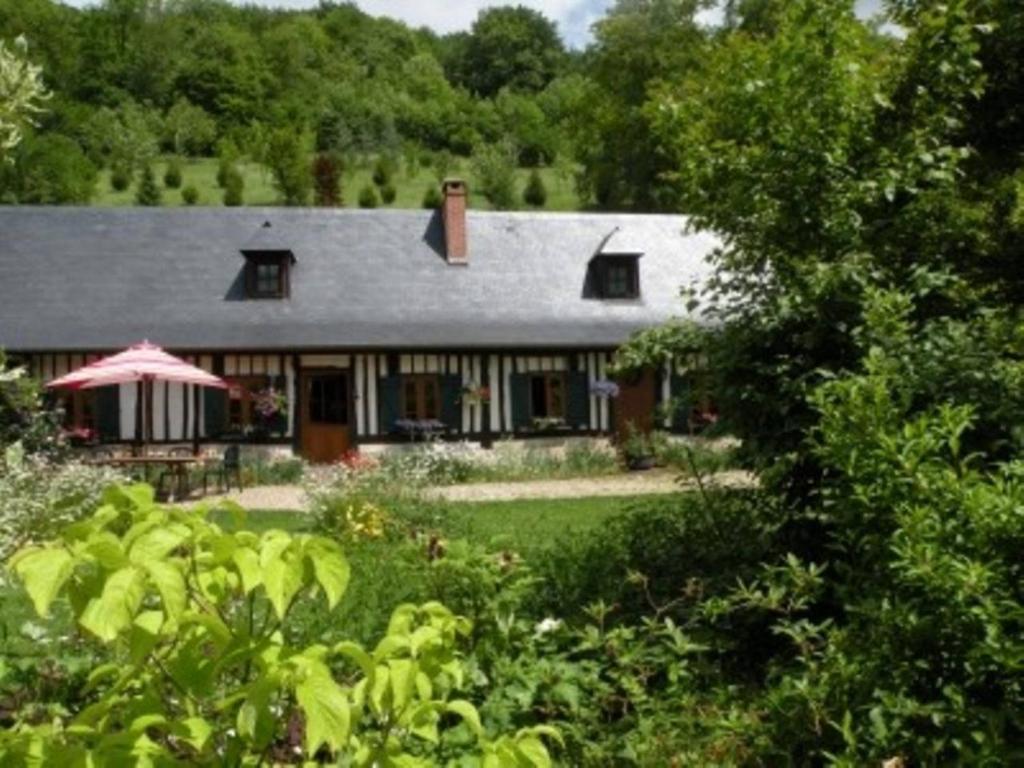 una casa con un jardín delante de ella en les orchidees sauvages en Touffreville-la-Corbeline