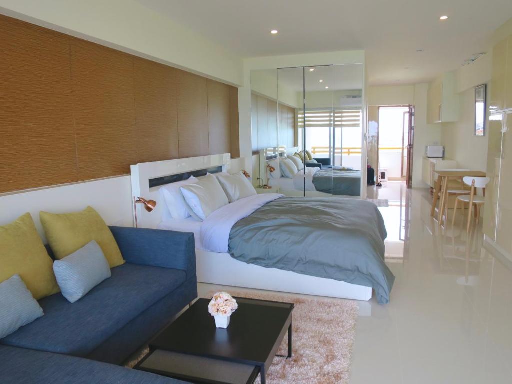 ナ・ジョムティエンにあるSunshine Beach Condotel by Luxの大きなベッドとソファのある寝室