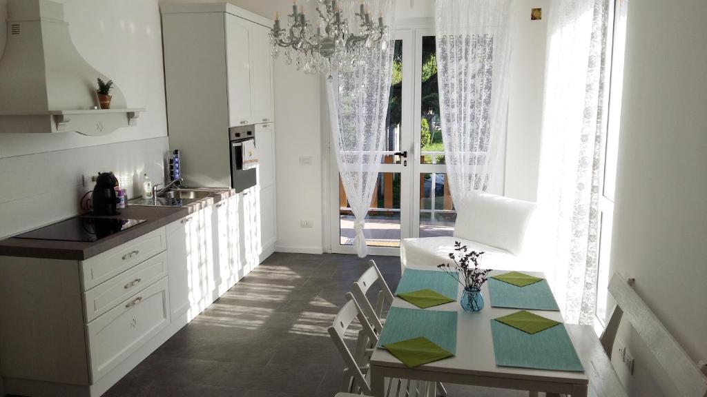cocina con mesa, sillas y ventana en La Casa dei Sogni en Brugherio