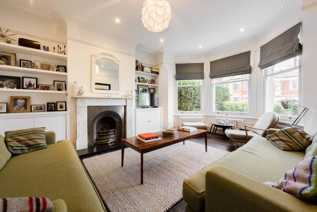sala de estar con 2 sofás y chimenea en Gorgeous, 4 Bed Victorian house in Dollis Hill, en Londres