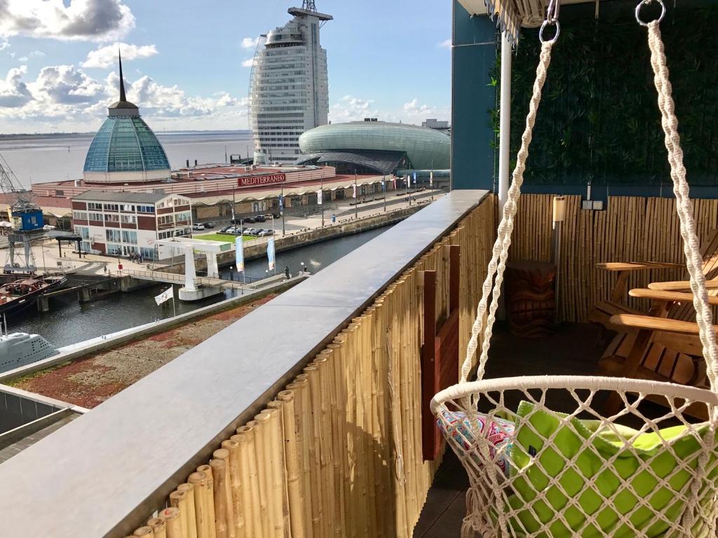 a balcony with a hammock and a view of a harbor at Coast House Moana in Bremerhaven