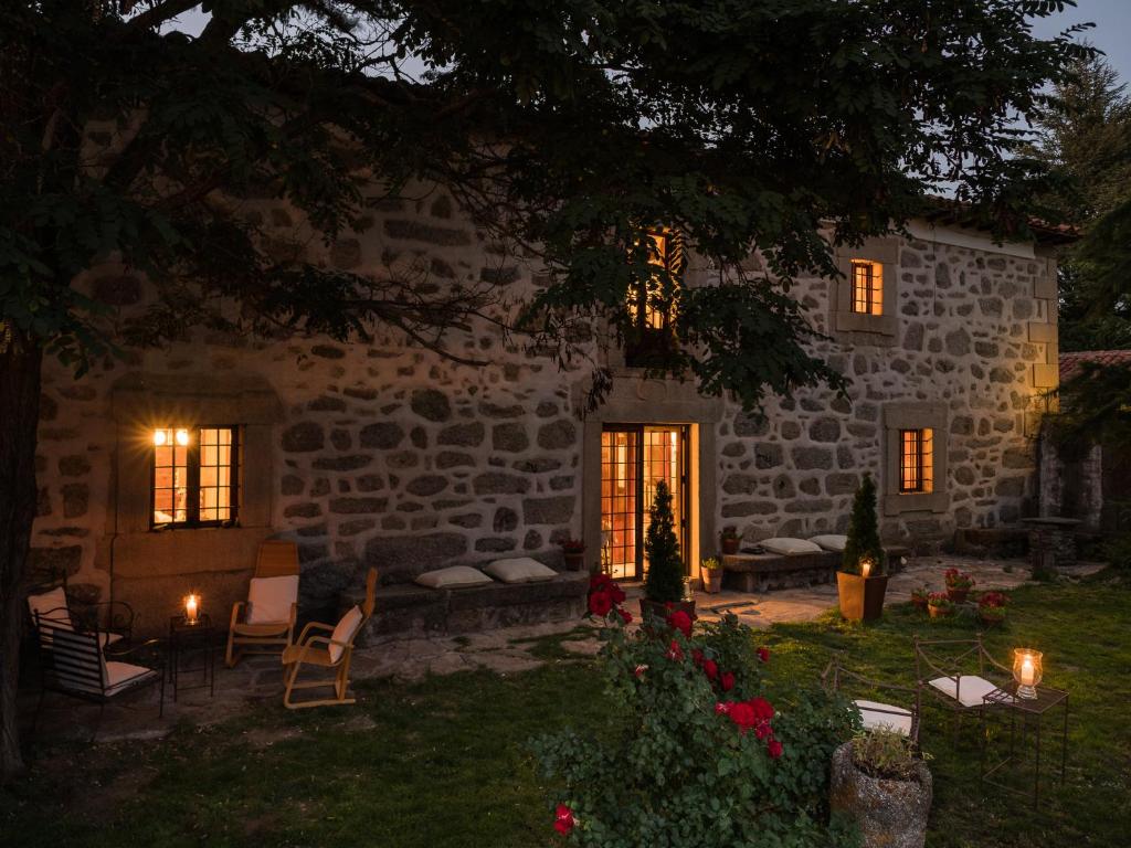 una casa de piedra con velas en el patio por la noche en Posada Real La Casa de Arriba en Navarredonda de Gredos