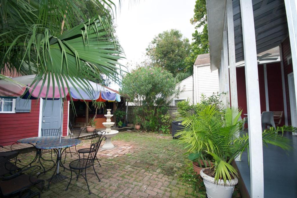 eine Terrasse mit einem Tisch, Stühlen und einem Sonnenschirm in der Unterkunft The Burgundy Bed and Breakfast in New Orleans