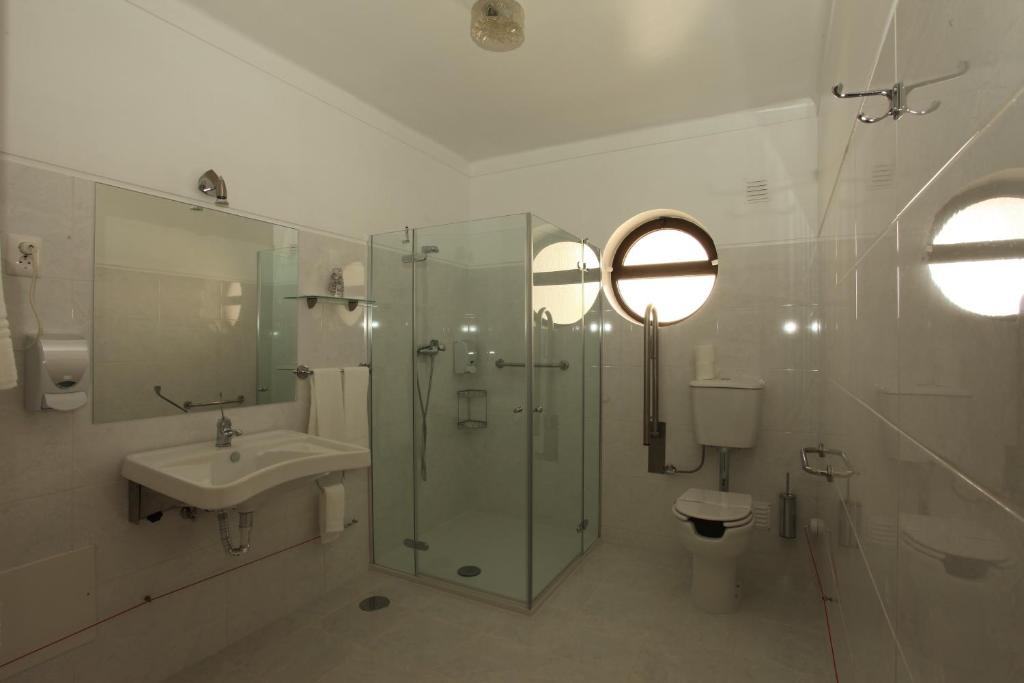 a bathroom with a shower and a sink and a toilet at Residencial Sra. da Lomba in Pinhanços