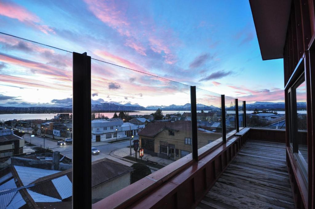 a balcony with a view of a city at sunset at Hotel Vendaval in Puerto Natales