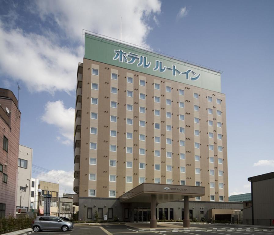 a hotel with a sign on the front of it at Hotel Route-Inn Omagari Ekimae in Daisen