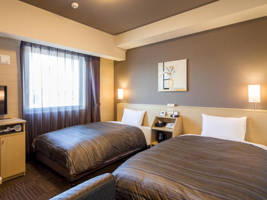 Postel nebo postele na pokoji v ubytování Hotel Route Inn Minami Yokkaichi