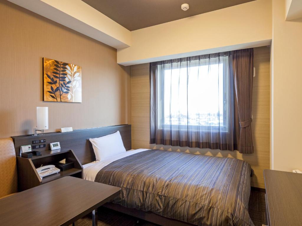 Postel nebo postele na pokoji v ubytování Hotel Route Inn Minami Yokkaichi