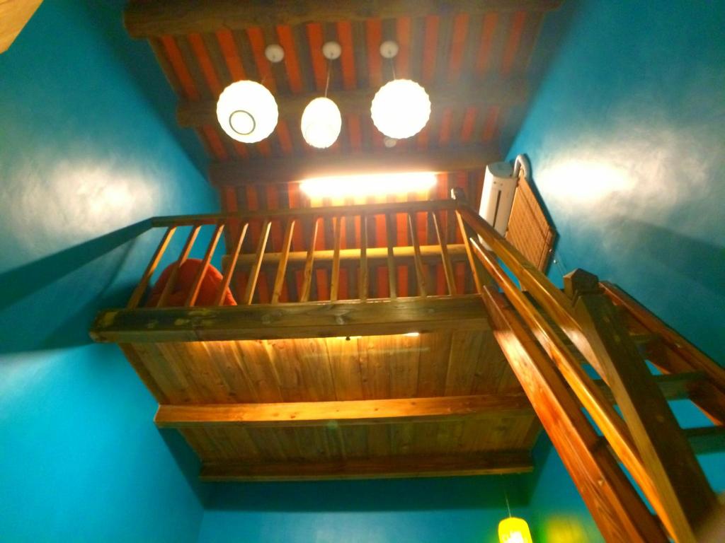 un escalier en bois avec une lumière au-dessus dans l'établissement Zhu Shan Homestay, à Jincheng