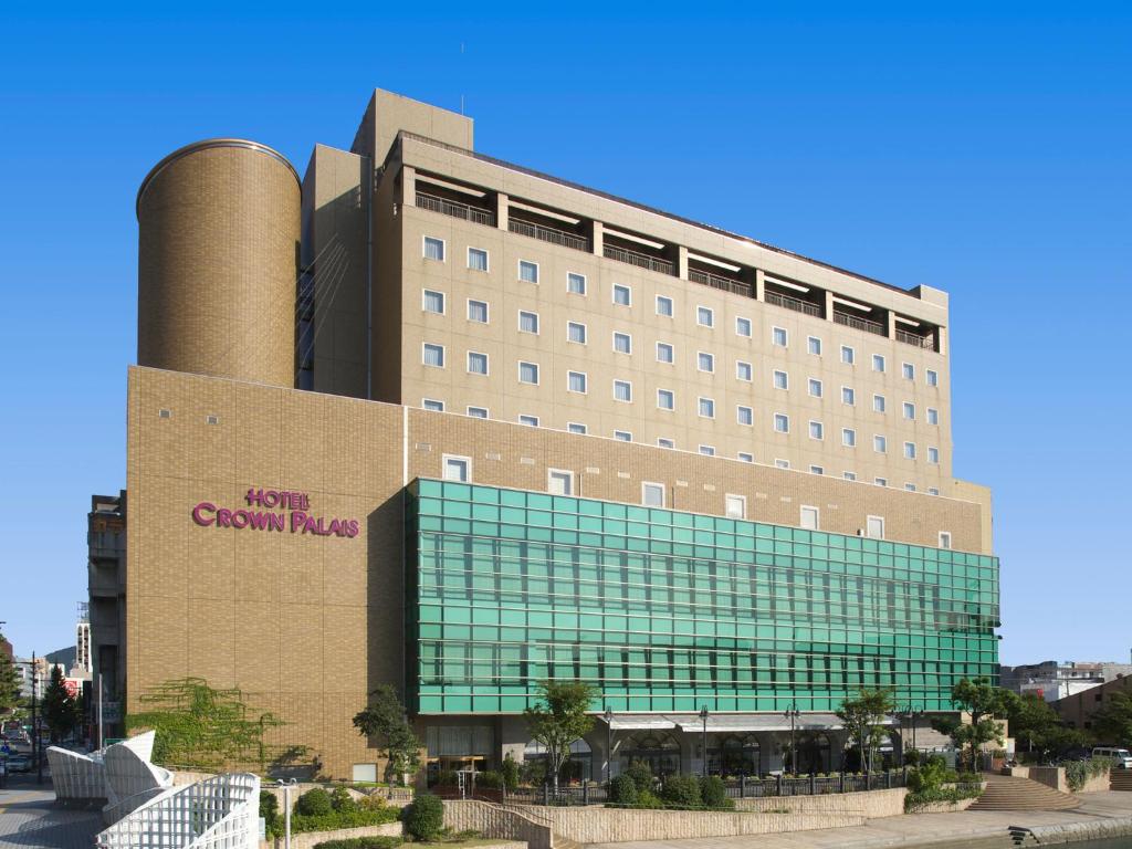 un grande edificio in mattoni con un edificio con una torre di raffreddamento di Hotel Crown Palais Kokura a Kitakyushu