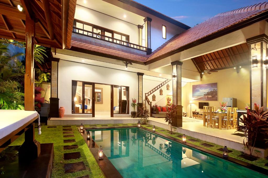 una casa con piscina di fronte a una casa di Concetta Villa Seminyak Beachside a Seminyak