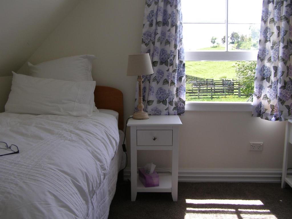 a bedroom with a bed and a window with curtains at Ashley Villa BnB in Takaka