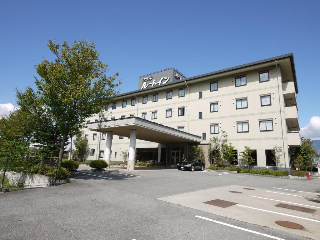 een hotel met een parkeerplaats ervoor bij Hotel Route-Inn Nakano in Nakano