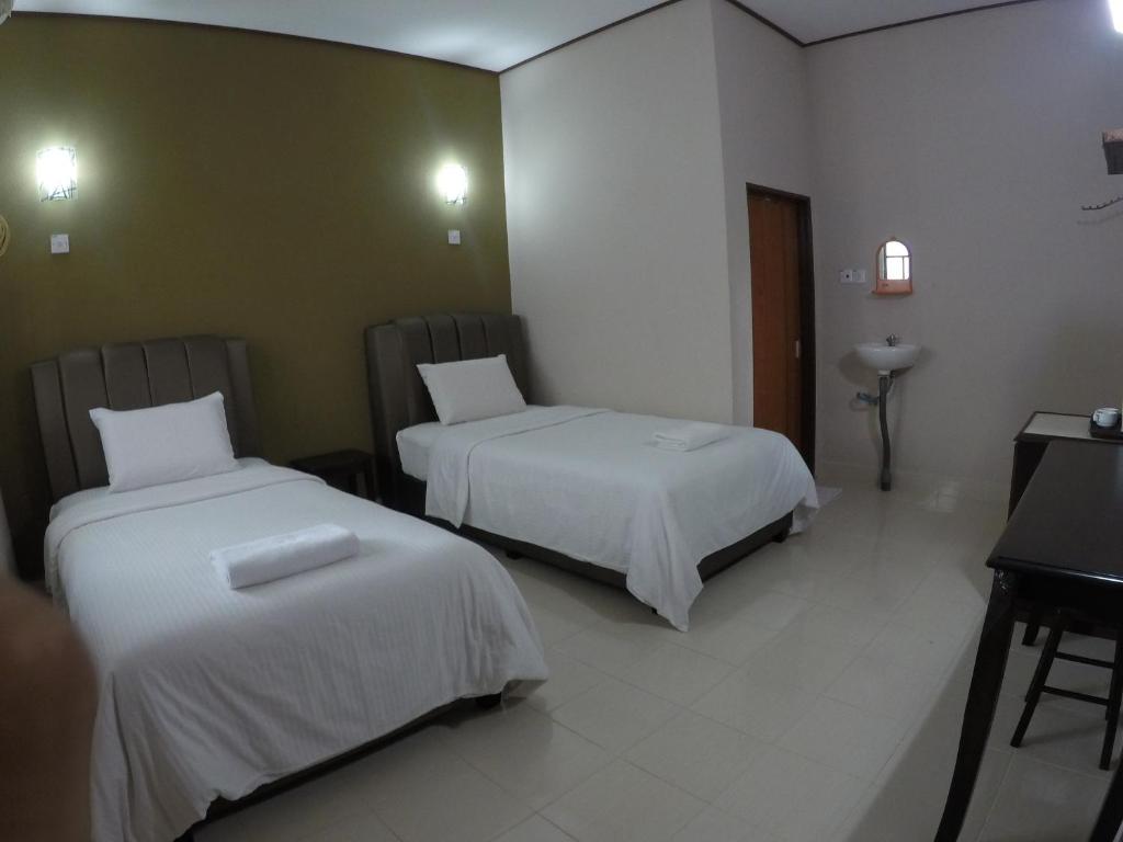 Postel nebo postele na pokoji v ubytování Nas Villaria Langkawi